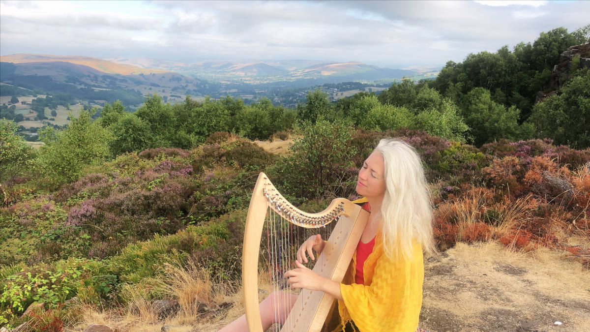 Photograph of singer and harpist Holly Honeychurch playing in the Peak District National Park